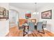 Modern dining room with hardwood floors, gray chairs, and a view of the kitchen through an arched pass-through at 4114 Breakview Dr # 110, Orlando, FL 32819