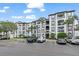 Beautiful multi-story condo building with white facade, dark trim, balconies, and lush tropical landscaping at 4114 Breakview Dr # 110, Orlando, FL 32819