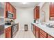 Modern kitchen with stainless steel appliances, wooden cabinets, and tile flooring and white countertops at 4114 Breakview Dr # 110, Orlando, FL 32819