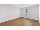 Bedroom featuring a ceiling fan, light gray walls, new flooring, and a bright window at 449 Timmonsville Way, The Villages, FL 32162