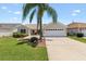 Charming single-story home featuring a well-maintained lawn and a two-car garage, offering curb appeal and convenience at 449 Timmonsville Way, The Villages, FL 32162