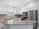 Modern kitchen with stainless steel appliances, granite countertops, and white cabinets, offering a stylish cooking space at 449 Timmonsville Way, The Villages, FL 32162