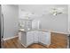 Bright kitchen boasts an island with white cabinets, granite countertops, and wood-look flooring at 449 Timmonsville Way, The Villages, FL 32162