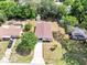 Aerial view of single-story home with fenced yard, mature trees, and detached storage buildings at 458 Spring Ln, Ocala, FL 34472