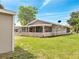 Back exterior view of the home with a screened in porch and large backyard space at 458 Spring Ln, Ocala, FL 34472
