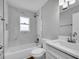Modern bathroom with shower over tub, white marble-style tile and white sink at 458 Spring Ln, Ocala, FL 34472