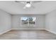 Bright bedroom features neutral walls, hardwood flooring, ceiling fan, and a large window with pleasant views at 458 Spring Ln, Ocala, FL 34472