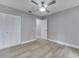 This bedroom features a ceiling fan, closet, and light wood flooring at 458 Spring Ln, Ocala, FL 34472