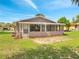 Back exterior view of home featuring a screened in porch with access to the grassy back yard at 458 Spring Ln, Ocala, FL 34472