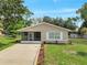 Charming single-story home featuring a screened porch, well-maintained lawn, and tidy landscaping at 458 Spring Ln, Ocala, FL 34472