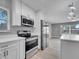 Modern white kitchen with stainless steel appliances, plenty of cabinets and breakfast bar, perfect for cooking at 458 Spring Ln, Ocala, FL 34472