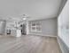 Open-concept living space with modern white cabinets, stainless steel appliances, and hardwood flooring at 458 Spring Ln, Ocala, FL 34472