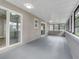 Enclosed sunroom featuring multiple windows, access to the backyard and gray painted floor and walls at 458 Spring Ln, Ocala, FL 34472