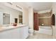 Well-lit bathroom with double sinks, framed mirrors, and a tiled shower-tub combo, designed for modern comfort at 4901 Stone Acres Cir, St Cloud, FL 34771