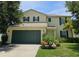 Two-story home with a well-manicured lawn, two-car garage, and dark green shutters at 4901 Stone Acres Cir, St Cloud, FL 34771
