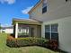 Exterior view of the screened patio with a ceiling fan and landscaped with flowers at 4901 Stone Acres Cir, St Cloud, FL 34771