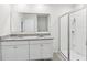 Contemporary bathroom featuring double sinks with granite, white cabinetry, and glass door shower at 585 Talisi Loop, St Cloud, FL 34771
