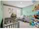 Charming Bedroom filled with toys, featuring a crib and comfortable chair at 585 Talisi Loop, St Cloud, FL 34771