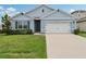 Charming single-story home with a well-manicured lawn and a two-car garage at 585 Talisi Loop, St Cloud, FL 34771