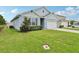 Well-maintained home with lush green lawn and attached two-car garage at 585 Talisi Loop, St Cloud, FL 34771