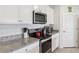 Modern kitchen with stainless steel appliances, granite countertops, and white cabinetry at 585 Talisi Loop, St Cloud, FL 34771