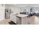 Spacious kitchen featuring an island with a sink, stainless steel appliances, and a dining table at 585 Talisi Loop, St Cloud, FL 34771