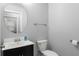 Powder room with dark vanity and round mirror at 605 Elbridge Dr, Kissimmee, FL 34758