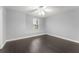 Bright bedroom featuring hardwood floors, a ceiling fan, and a window with natural light at 605 Elbridge Dr, Kissimmee, FL 34758