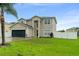 Charming two-story home with a well-maintained lawn and a two-car garage at 605 Elbridge Dr, Kissimmee, FL 34758