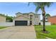 Two-story home with modern curb appeal, attached garage, and well-kept lawn at 605 Elbridge Dr, Kissimmee, FL 34758