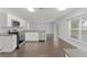 Modern kitchen featuring white cabinets, stainless steel appliances, and hardwood flooring at 605 Elbridge Dr, Kissimmee, FL 34758