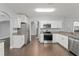 Kitchen features stainless steel appliances, white cabinets and granite countertops at 605 Elbridge Dr, Kissimmee, FL 34758