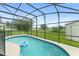 Private backyard features a screened-in pool and grassy surroundings at 605 Elbridge Dr, Kissimmee, FL 34758
