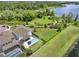 Aerial view of a home with a pool, lush landscaping, and serene lakeside backdrop creating a private oasis at 6905 Cucamelon Ct, Windermere, FL 34786