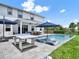 Spacious backyard featuring a private pool, lounge chairs, and a covered patio with outdoor dining furniture at 6905 Cucamelon Ct, Windermere, FL 34786