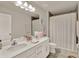Well-lit bathroom with double vanity, framed mirror, and a shower-tub combination with neutral accents at 6905 Cucamelon Ct, Windermere, FL 34786