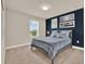 Cozy bedroom with a blue accent wall, neutral bedding, and serene decor for a peaceful retreat at 6905 Cucamelon Ct, Windermere, FL 34786
