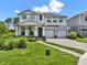 Traditional two-story home featuring a manicured front lawn, a two-car garage, and a welcoming entryway at 6905 Cucamelon Ct, Windermere, FL 34786