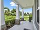 Inviting covered front porch area featuring beautiful outdoor views, decorative columns, and manicured landscaping at 6905 Cucamelon Ct, Windermere, FL 34786