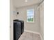 Functional laundry room with modern black washer and dryer and natural light at 6905 Cucamelon Ct, Windermere, FL 34786