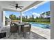 Beautiful outdoor patio with a dining table, fan, grill, and view of the sparkling pool and backyard at 6905 Cucamelon Ct, Windermere, FL 34786