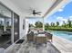 Relaxing covered patio area with dining set, grill and a view of the private pool and lush landscaping at 6905 Cucamelon Ct, Windermere, FL 34786