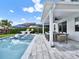 Outdoor living space with a stunning pool, covered patio, grill area, and comfortable seating for entertaining at 6905 Cucamelon Ct, Windermere, FL 34786