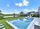 Lovely backyard pool area with clear water, lounge chairs, lush landscaping, and view of the lake at 6905 Cucamelon Ct, Windermere, FL 34786