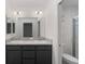 A modern bathroom with double sinks, gray cabinets, and a glass-enclosed shower at 744 Barron Pl, The Villages, FL 32163