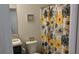 Bathroom with dark wood cabinets, neutral countertop, and floral shower curtain and decor at 744 Barron Pl, The Villages, FL 32163