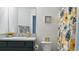 Bathroom with dark wood cabinets, neutral countertop, and floral shower curtain and decor at 744 Barron Pl, The Villages, FL 32163