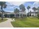 Elegant community building featuring classic architecture, lush landscaping, and inviting outdoor spaces with palm trees at 744 Barron Pl, The Villages, FL 32163