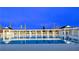 Beautiful community pool with pristine water, surrounded by white pergola and palm trees at 744 Barron Pl, The Villages, FL 32163