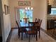 A cozy dining area showcases a wooden table with seating for six and sliding glass doors to the backyard at 744 Barron Pl, The Villages, FL 32163